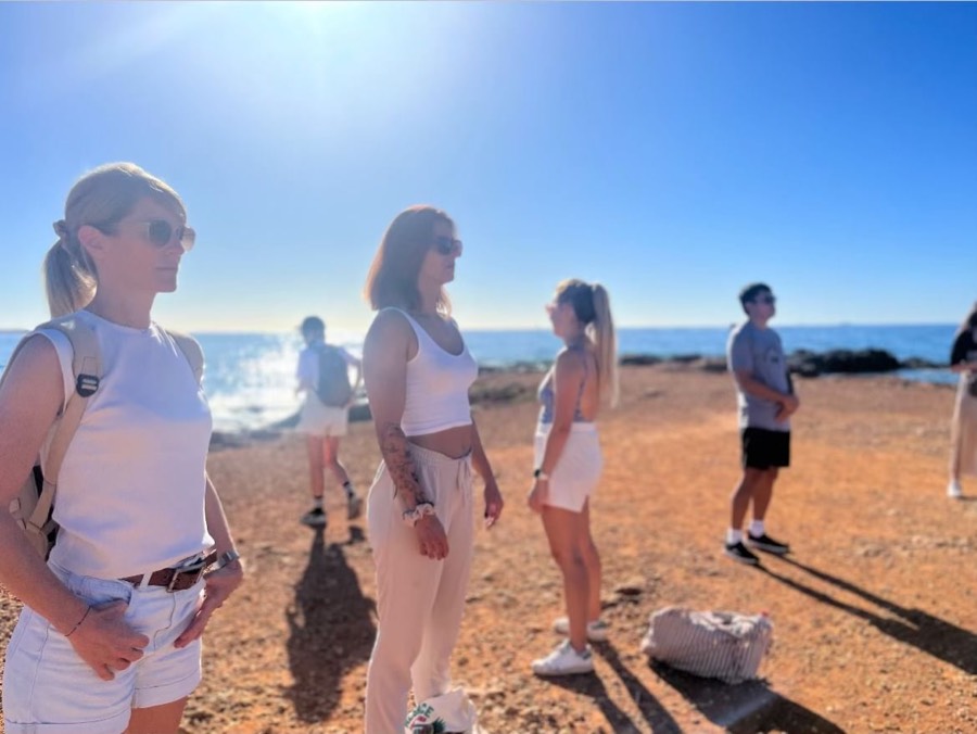 Participantes sur une plage de sable rouge